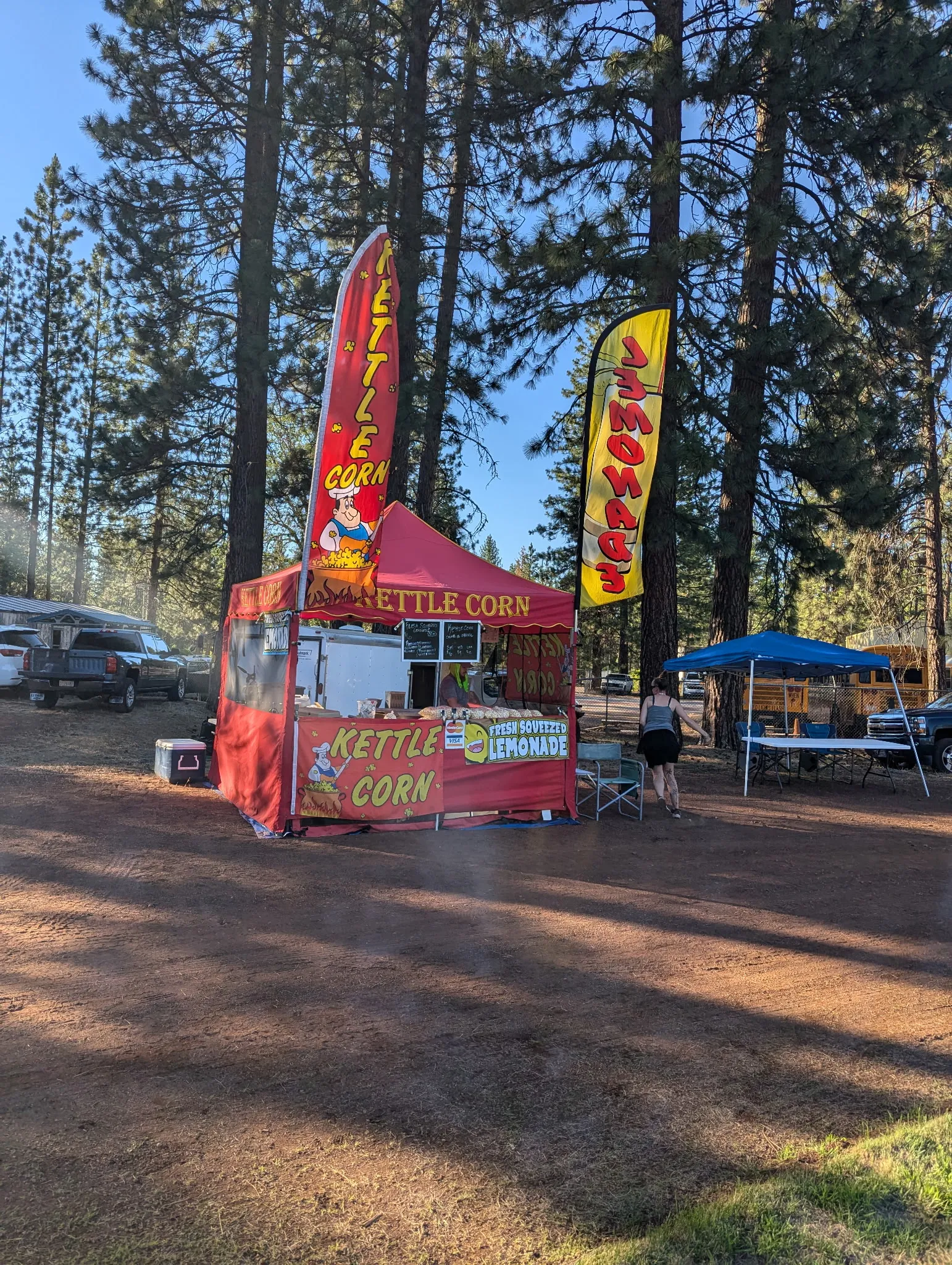 Baker's red kettle corn tent among the pines at a mountain event
